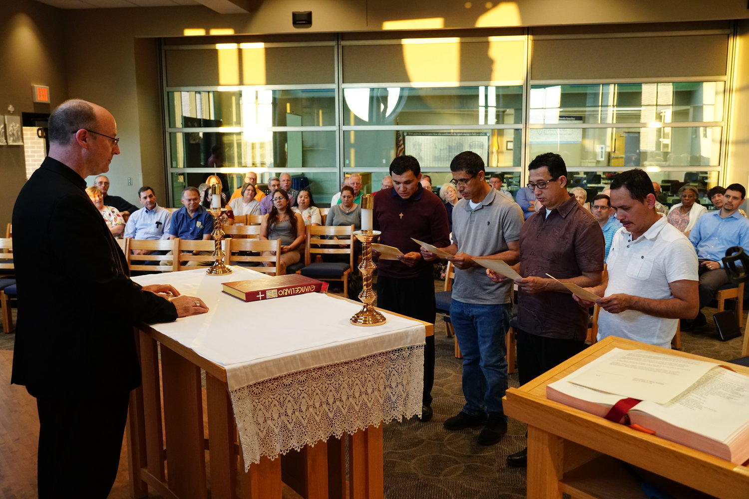 WITH CHRISTIAN OBEDIENCE: Pacheco, who are candidates for the diaconate make their profession of faith and oath of fidelity before Bishop W. Shawn McKnight Aug. 16 in Columbia. They and Enrique Castro (seated, right) hope to be ordained at 2 p.m. on Oct. 13 in the Cathedral of St. Joseph.